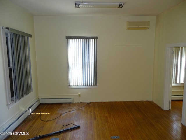 empty room featuring a wall unit AC, hardwood / wood-style floors, and a baseboard heating unit