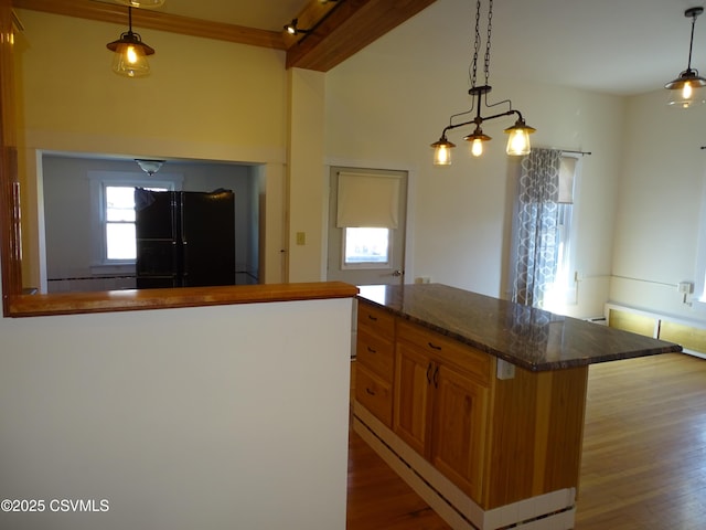 kitchen featuring black fridge with ice dispenser, a center island, decorative light fixtures, and wood-type flooring