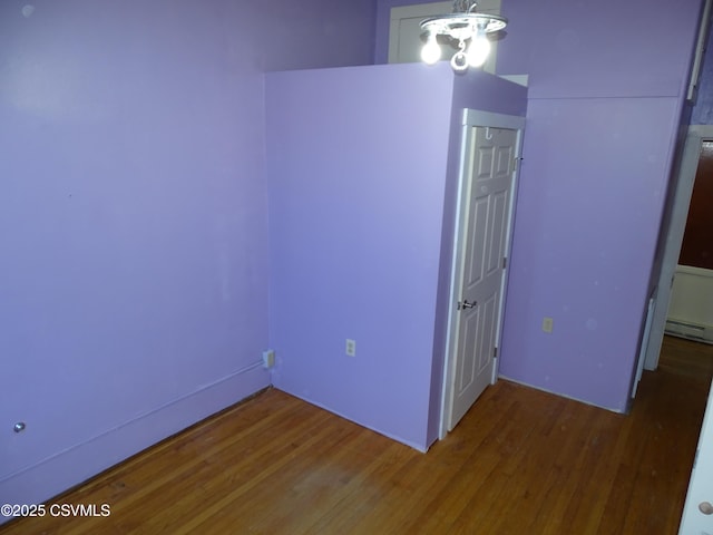 spare room featuring dark hardwood / wood-style flooring and a baseboard radiator