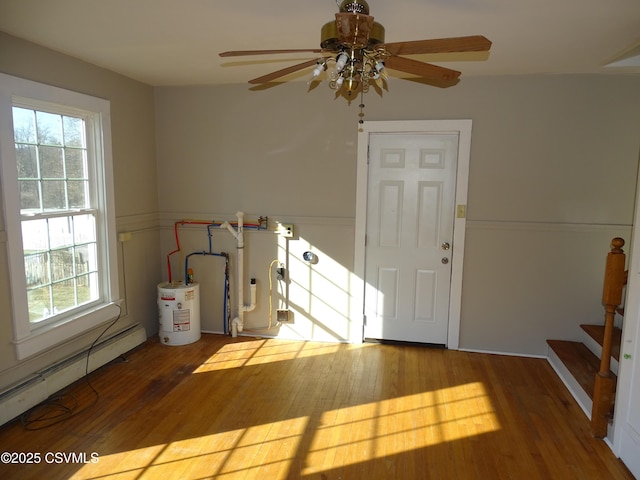 foyer entrance featuring gas water heater, baseboard heating, hardwood / wood-style flooring, and ceiling fan