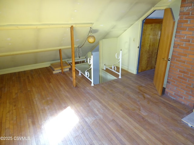 additional living space featuring hardwood / wood-style floors and lofted ceiling