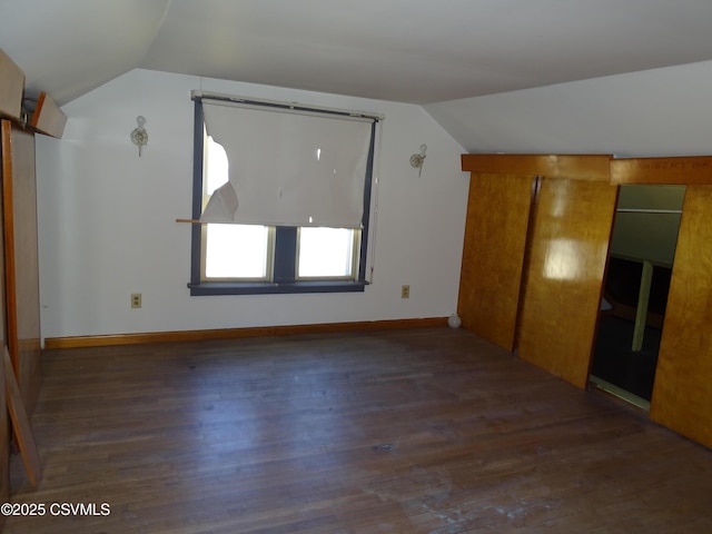 bonus room featuring dark wood-type flooring and vaulted ceiling