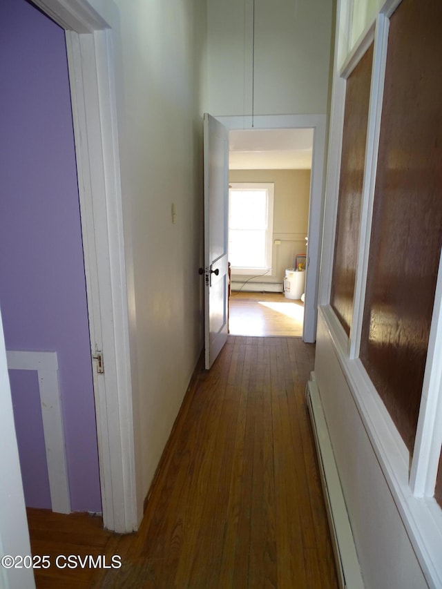 hallway featuring dark wood-type flooring and a baseboard heating unit