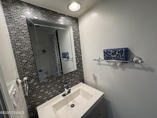 bathroom with decorative backsplash and vanity