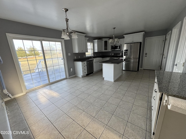 kitchen with white cabinetry, hanging light fixtures, a notable chandelier, and appliances with stainless steel finishes