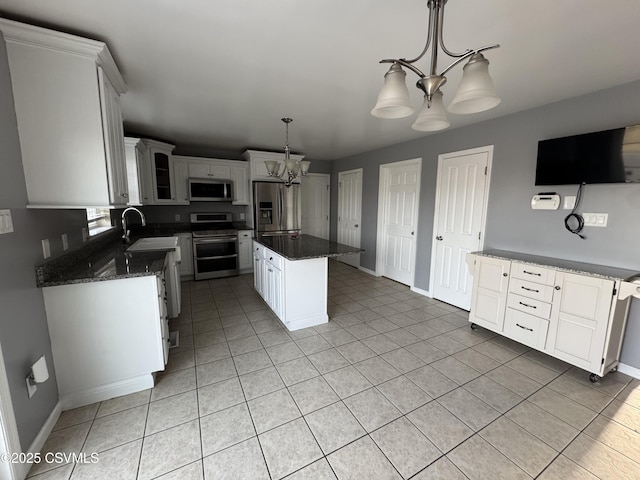 kitchen with a chandelier, stainless steel appliances, a kitchen island, and white cabinetry