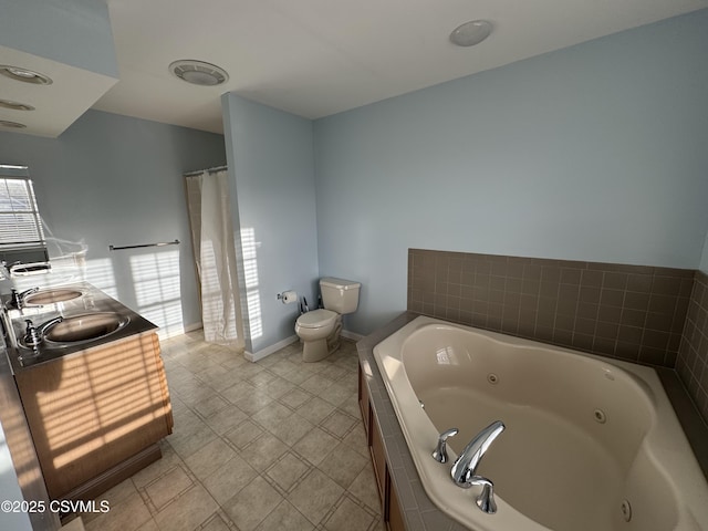 bathroom with vanity, toilet, and tiled tub