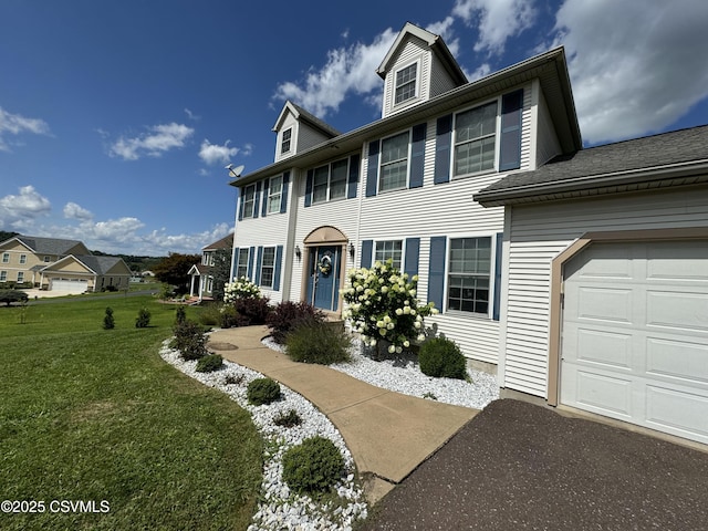 view of front of property featuring a front yard and a garage