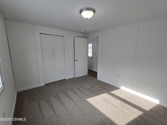 unfurnished bedroom featuring dark carpet and a closet