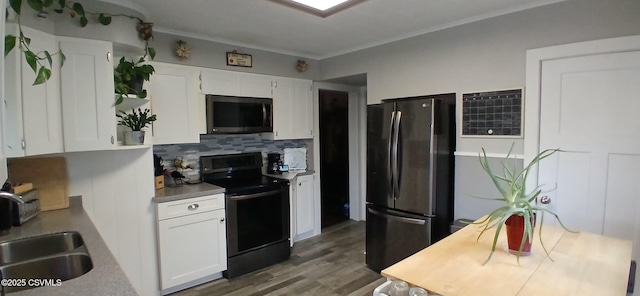 kitchen featuring black electric range, white cabinetry, stainless steel refrigerator, and sink