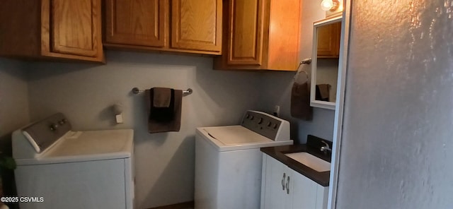 washroom featuring cabinets, independent washer and dryer, and sink