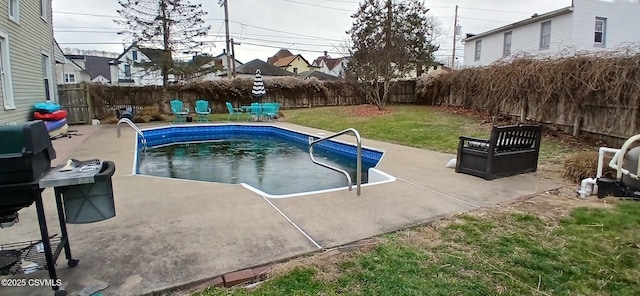 view of pool with a patio area and a lawn