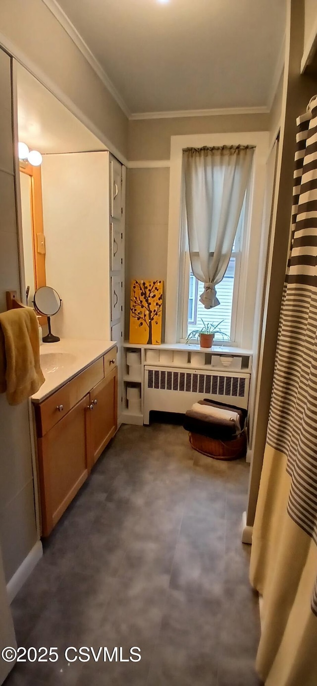 interior space with radiator heating unit, vanity, and ornamental molding