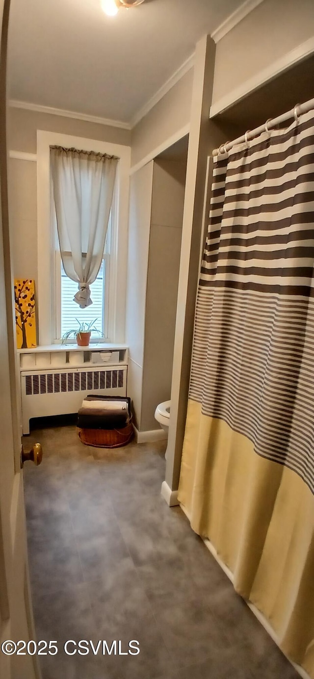 bathroom with toilet, ornamental molding, and radiator