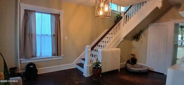 stairway with hardwood / wood-style floors, radiator heating unit, and a wealth of natural light