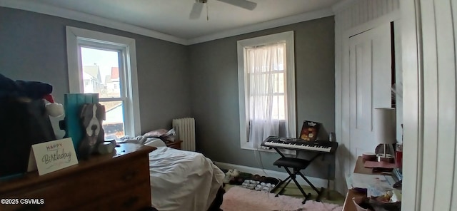 bedroom featuring ceiling fan, crown molding, and radiator