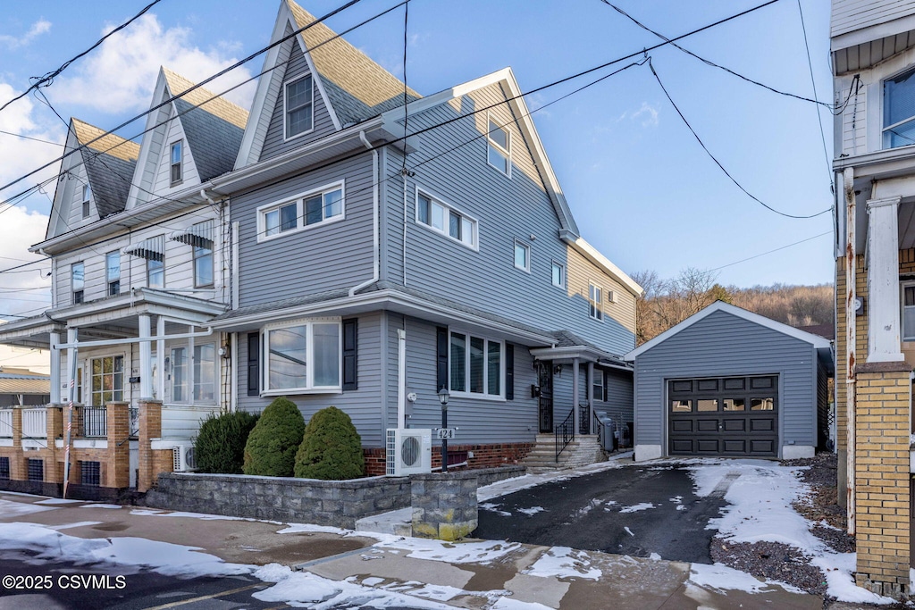 view of front of home featuring ac unit, a garage, and an outdoor structure