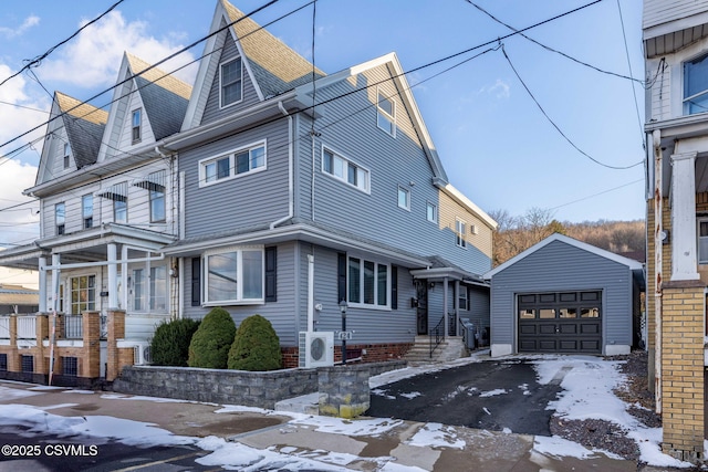 view of front of home featuring ac unit, a garage, and an outdoor structure