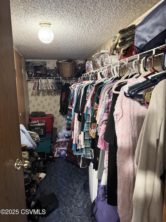 walk in closet featuring dark carpet