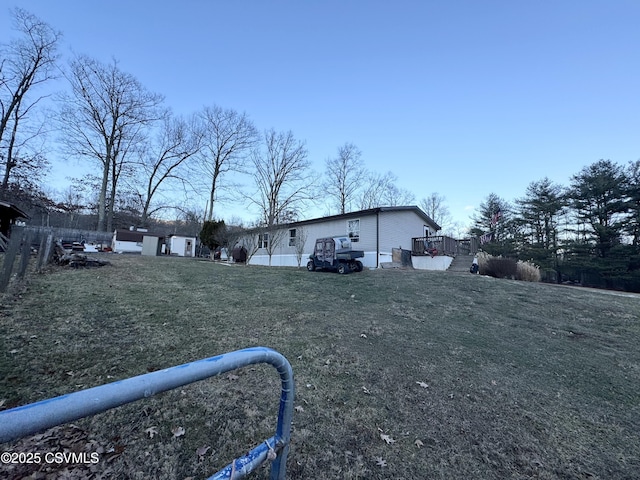 view of side of property featuring a wooden deck and a yard