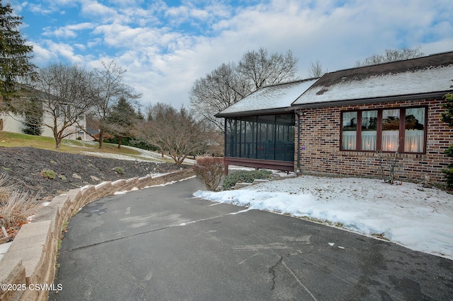 view of side of home featuring a sunroom and brick siding