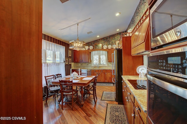 dining room featuring lofted ceiling and light wood-type flooring