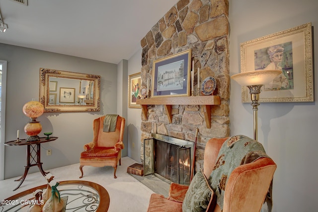 sitting room with lofted ceiling, carpet, and a stone fireplace