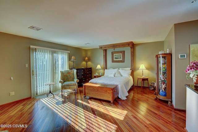 bedroom featuring access to outside, wood-type flooring, visible vents, and baseboards