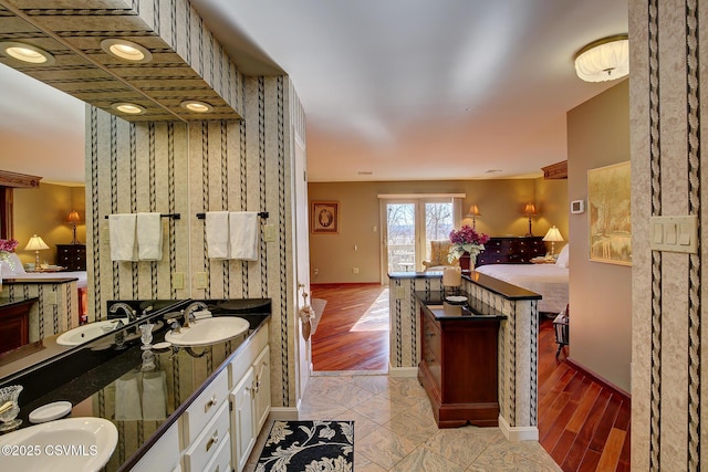 kitchen with light wood-type flooring, a sink, and white cabinetry