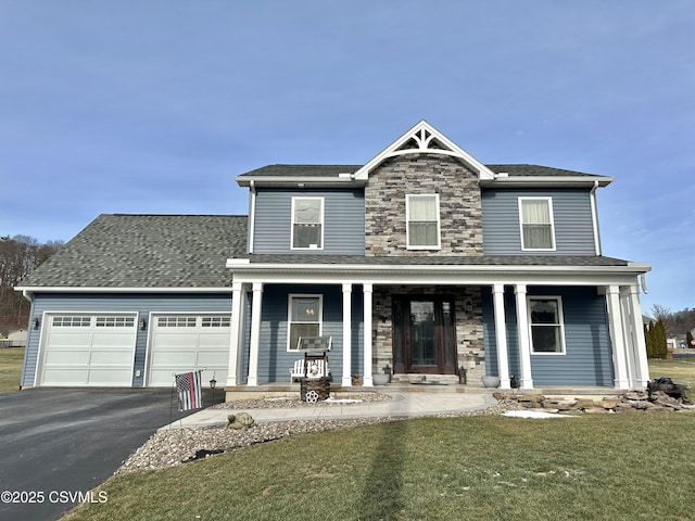 view of front of home featuring a porch, a garage, and a front lawn