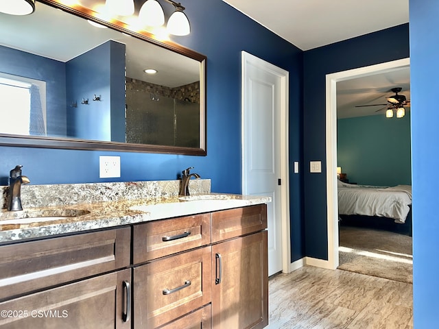 bathroom featuring a shower, ceiling fan, and vanity