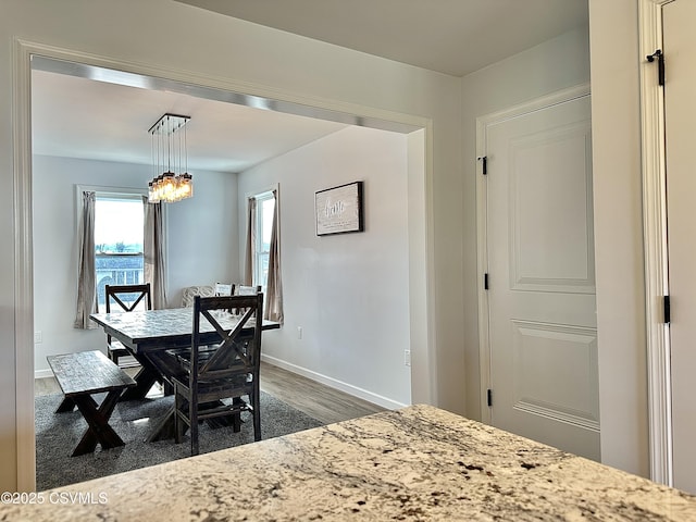 dining space with dark hardwood / wood-style flooring and an inviting chandelier