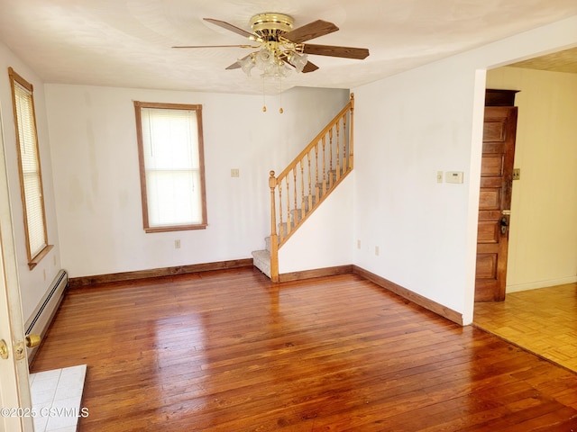 unfurnished room with hardwood / wood-style flooring, baseboard heating, and ceiling fan