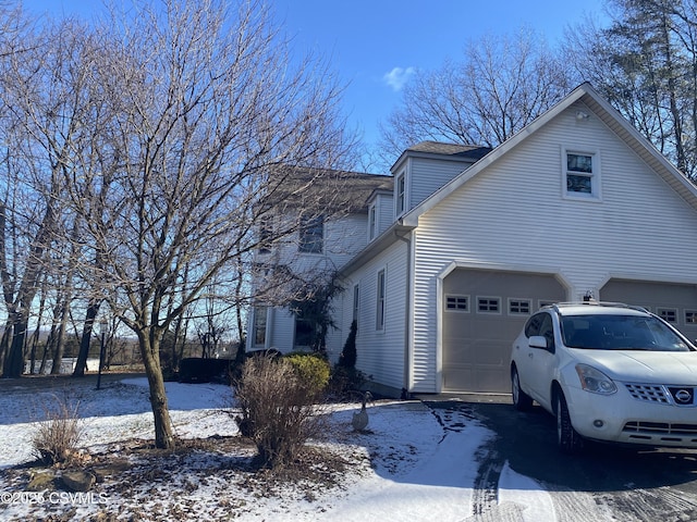 view of snowy exterior with a garage