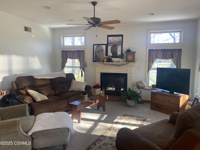 living room featuring ceiling fan, light colored carpet, and a wealth of natural light