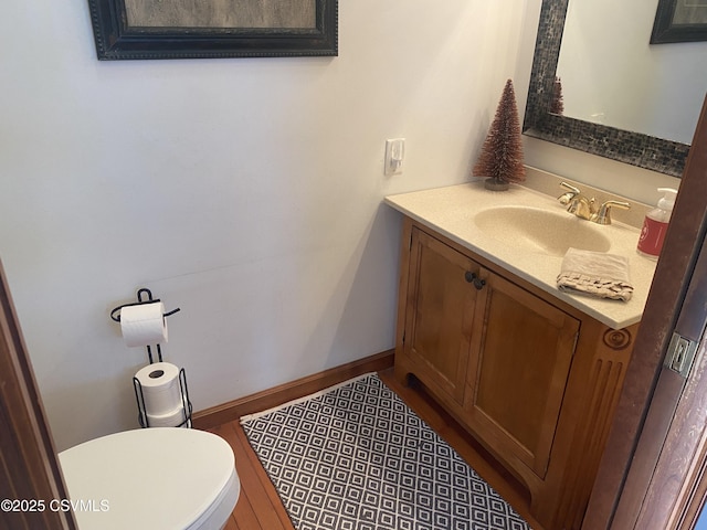 bathroom with hardwood / wood-style floors, vanity, and toilet