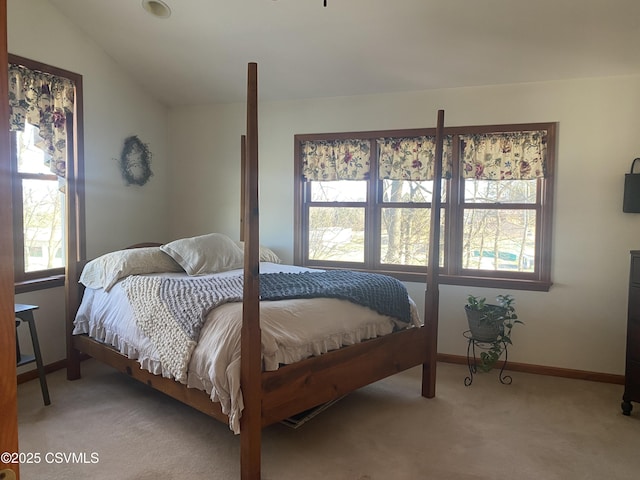 carpeted bedroom featuring multiple windows and vaulted ceiling