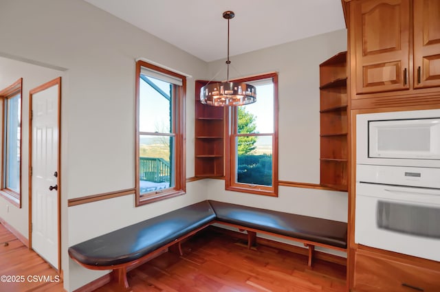 unfurnished dining area featuring light wood-type flooring and a chandelier