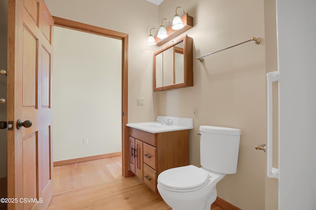 bathroom featuring wood-type flooring, toilet, and vanity