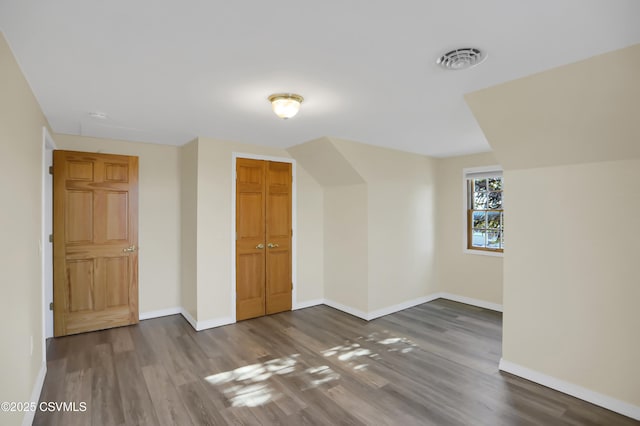 additional living space with dark wood-type flooring