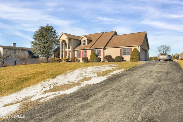 view of front of property with a front lawn and a garage