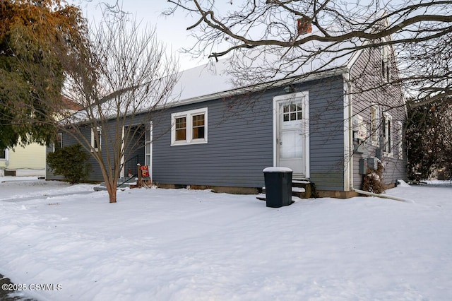 view of snow covered rear of property