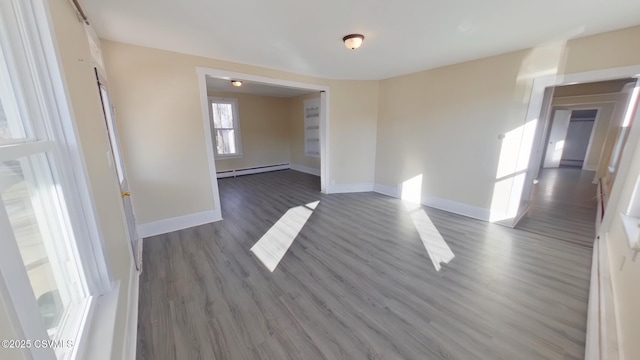 unfurnished room with a baseboard radiator and dark hardwood / wood-style flooring