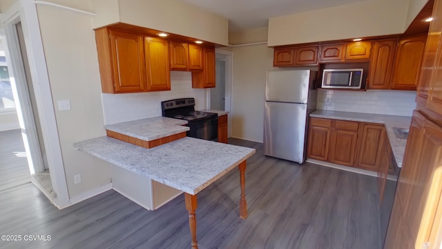 kitchen with decorative backsplash, fridge, black range with electric cooktop, and hardwood / wood-style flooring