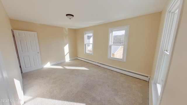 empty room with light colored carpet and a baseboard radiator