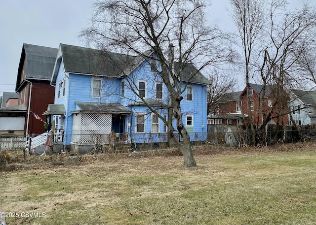 rear view of property featuring a yard