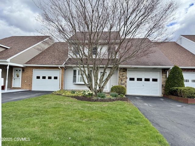 view of front of house featuring a front yard, a garage, a shingled roof, and aphalt driveway