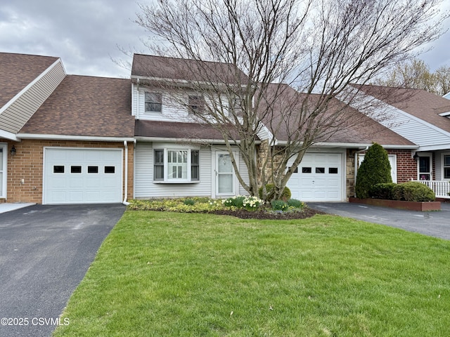 traditional-style house featuring driveway, roof with shingles, a front lawn, and a garage