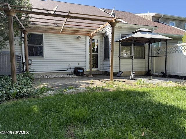 rear view of house featuring a gazebo, a patio area, roof with shingles, a pergola, and fence