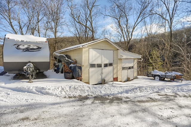 snow covered structure with a garage